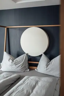 a bedroom with a bed with a mirror above it at Haus am Turm in Vipiteno