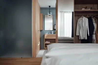 a bedroom with a bed and a closet and a window at Haus am Turm in Vipiteno