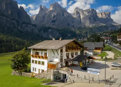 a hotel with mountains in the background at Garnì Bel Air in Colfosco