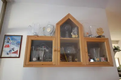 a wooden cabinet with glass doors on a wall at Garnì Bel Air in Colfosco