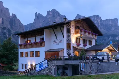a hotel with mountains in the background at Garnì Bel Air in Colfosco