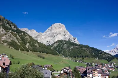 a village in a valley with a mountain in the background at Pensione Sellablick in Colfosco