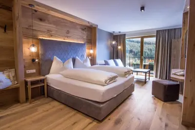 a bedroom with a large bed in a room at Alpin Hotel Sonnblick in Perca