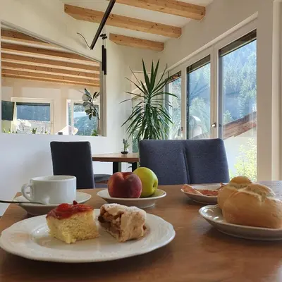 a table with plates of food on top of it at Haus Herta B&B in Nova Levante