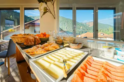 a breakfast buffet with food on a table with a view at Haus Herta B&B in Nova Levante