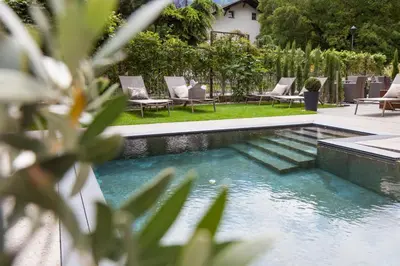a swimming pool in a yard with chairs next to it at Hotel Stefanshof in Plaus