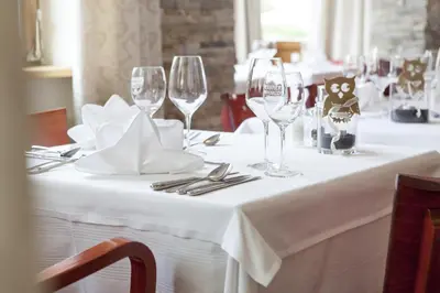 a table with wine glasses and napkins on it at Hotel Stefanshof in Plaus