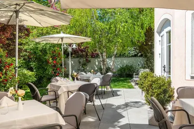 a patio with tables and chairs and umbrellas at Hotel Rosskopf in Vipiteno