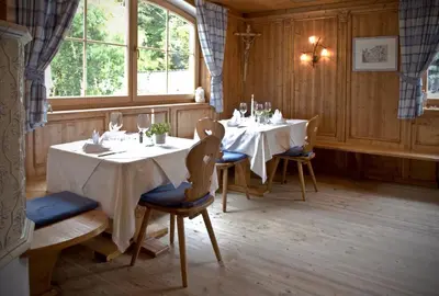a dining room with two tables and chairs and a window at Hotel Rosskopf in Vipiteno