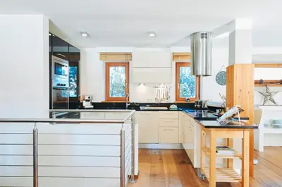 a kitchen with white cabinets and a black counter top at Casa Zilli in La Villa