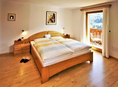 a house covered in snow with a mountain in the background at Apartment Larjëi in Ortisei