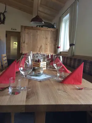 a wooden table with red napkins and wine glasses on it at Dillerhof in Laion