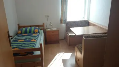 a small bedroom with a bed and a desk at Dillerhof in Laion