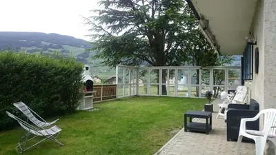 a patio with white chairs and a green yard at Dillerhof in Laion