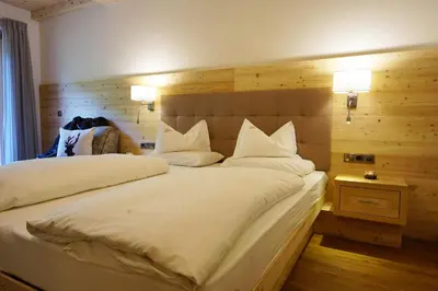 a bedroom with two beds with white pillows at Garnì Tofana in Corvara in Badia