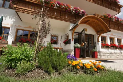 a building with flowers in front of it at Garnì Tofana in Corvara in Badia