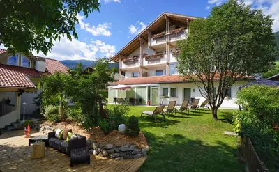 a building with a yard with chairs in front of it at Residence Walder in Falzes