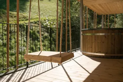 a swing on a porch with a fence at Naturhotel Rainer in Racines