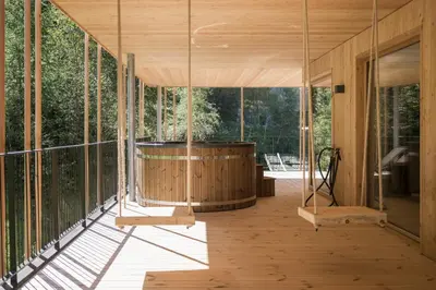 a glass house with a hot tub on a deck at Naturhotel Rainer in Racines