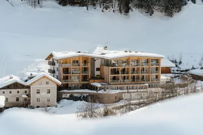 a large building with snow on top of it at Naturhotel Rainer in Racines