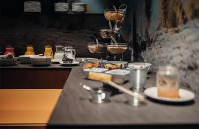a table with plates of food on a counter at Plan Murin - Authentic Dolomites Hotel in La Valle