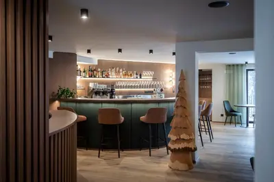 a bar in a restaurant with a christmas tree at Plan Murin - Authentic Dolomites Hotel in La Valle