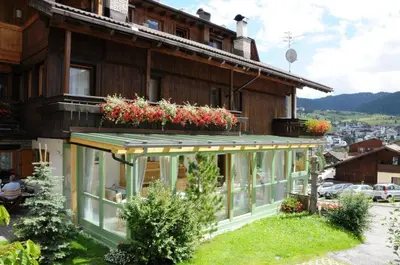 a large mountain with trees in front of it at Ciasa Confolia in Corvara in Badia