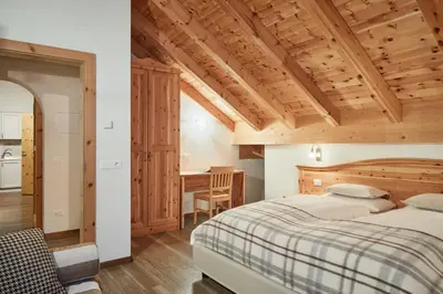 a bedroom with a bed and a desk at Residence Baron in San Vigilio Di Marebbe