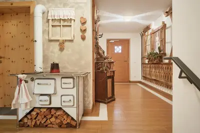 a kitchen with a stove with a pile of wood at Residence Baron in San Vigilio Di Marebbe