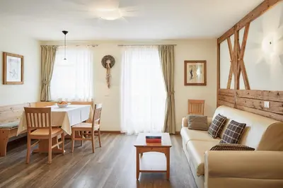 a living room and dining room with a table and a couch at Residence Baron in San Vigilio Di Marebbe