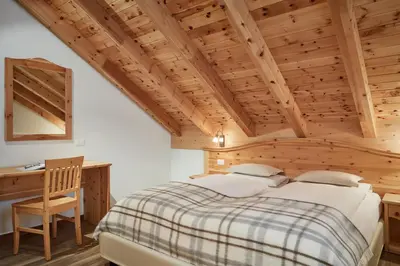 a bedroom with a large bed and a desk at Residence Baron in San Vigilio Di Marebbe