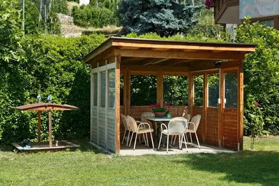 a gazebo with a table and chairs in a yard at Residence Neuhof in Tirolo