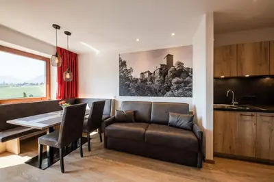 a dining room with a couch and a table at Residence Neuhof in Tirolo