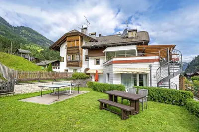 a house with a table and a bench in the yard at Apartments Mirandula in Ortisei