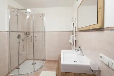 a bathroom with a shower and a white sink at Apartments Mirandula in Ortisei