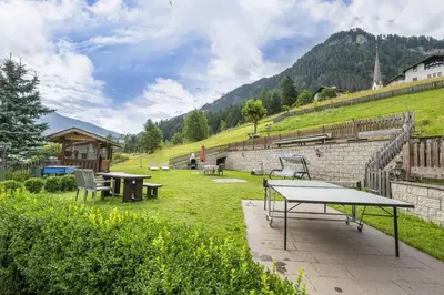 a ping pong table and benches in a field at Apartments Mirandula in Ortisei