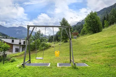 an empty swing set on a hill in a field at Apartments Mirandula in Ortisei
