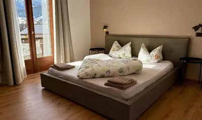 a bed with pillows on it in a bedroom at NoveCase Smart Holidays - Gasthof Neunhaeusern in Rasùn di Sotto