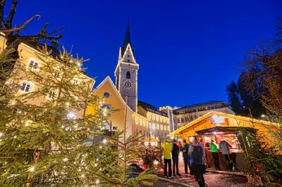 a christmas market in front of a church with a tower at NoveCase Smart Holidays - Gasthof Neunhaeusern in Rasùn di Sotto