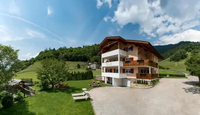a large house with a balcony on a hill at Pension Talblick in Laion