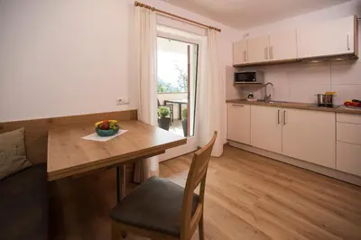 a kitchen with a table with a bowl of fruit on it at Pension Talblick in Laion