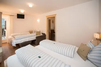 a living room with two beds and a television at Pension Talblick in Laion
