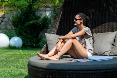 a woman sitting on a wicker chair at Residence Mignon in Rifiano