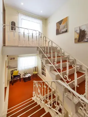 a spiral staircase in a living room with orange carpet at Residence Mignon in Rifiano