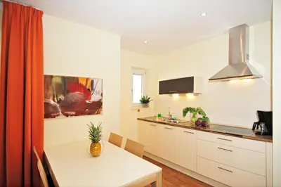 a kitchen with a white table and a kitchen with a sink at Residence Mignon in Rifiano