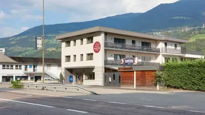 a building on the side of a street with a mountain at Appartments Waage in Bressanone