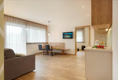 a living room with a kitchen and a dining room at Appartments Waage in Bressanone