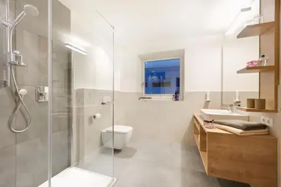 a bathroom with a shower and a toilet and a sink at Appartments Waage in Bressanone