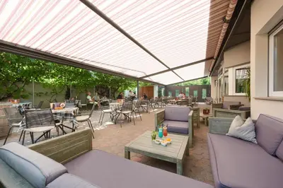an outdoor patio with couches and tables and chairs at Appartments Waage in Bressanone