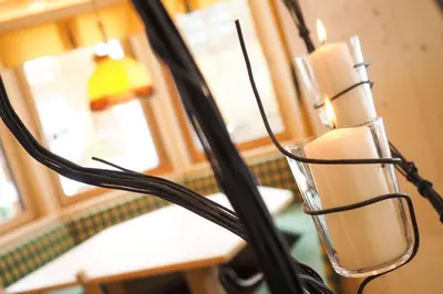 a group of candles in a glass holder on a lamp at Cesa Edelweiss Living & Spa in Campitello di Fassa